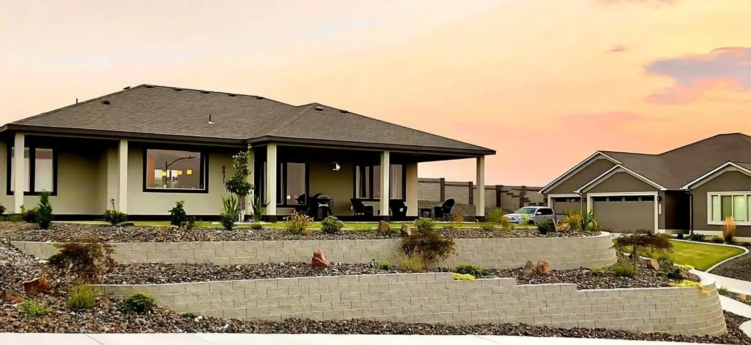 House with rock and stone wall landscaping at sunset