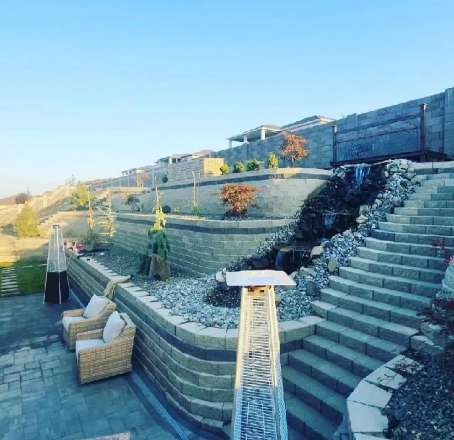 Terraced block walls with stairs and patio seating